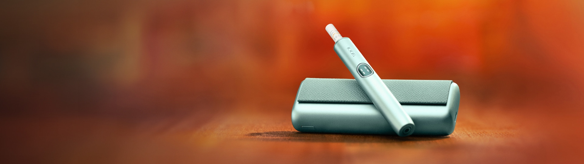 An IQOS device held by one person and a smartphone held by another person.